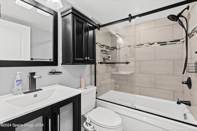 full bathroom featuring combined bath / shower with glass door, toilet, and vanity