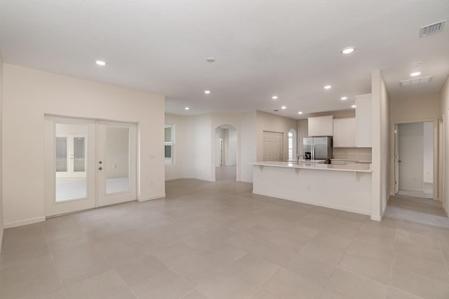 unfurnished living room featuring french doors and sink