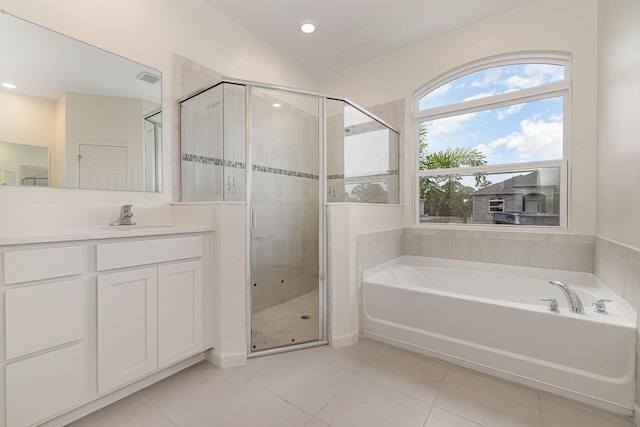 bathroom with vaulted ceiling, vanity, plus walk in shower, and tile patterned flooring