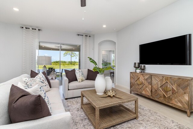 living room featuring light wood-type flooring and ceiling fan