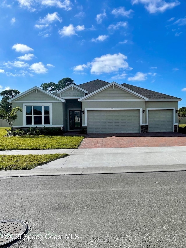 single story home with a garage and a front lawn