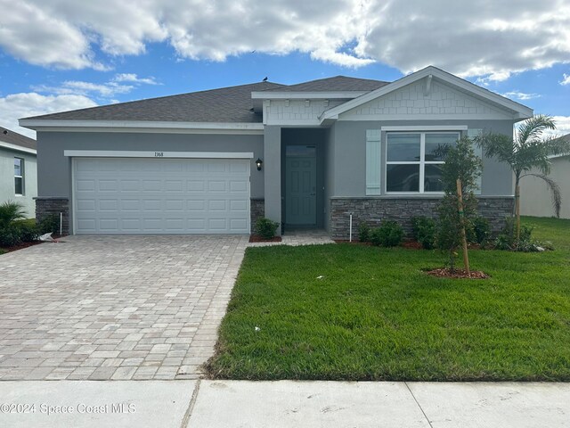 view of front of home with a garage and a front lawn