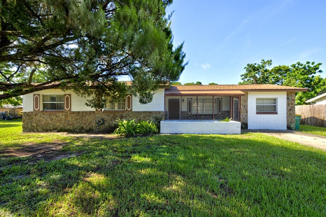 ranch-style home featuring a front yard, concrete driveway, and fence