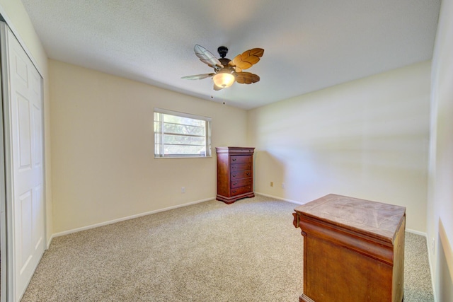 unfurnished bedroom featuring baseboards, ceiling fan, a textured ceiling, carpet floors, and a closet