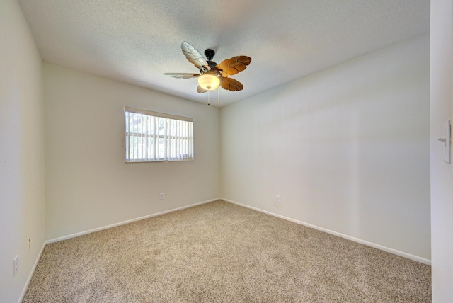 carpeted spare room with baseboards, a ceiling fan, and a textured ceiling