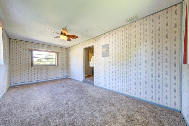 empty room with wallpapered walls, electric panel, visible vents, ceiling fan, and carpet floors