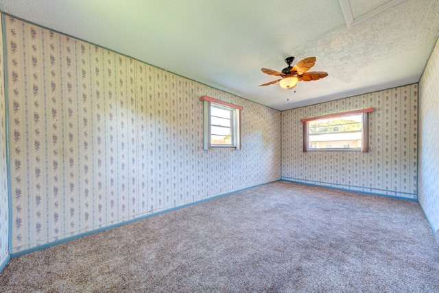 carpeted spare room featuring a textured ceiling and ceiling fan