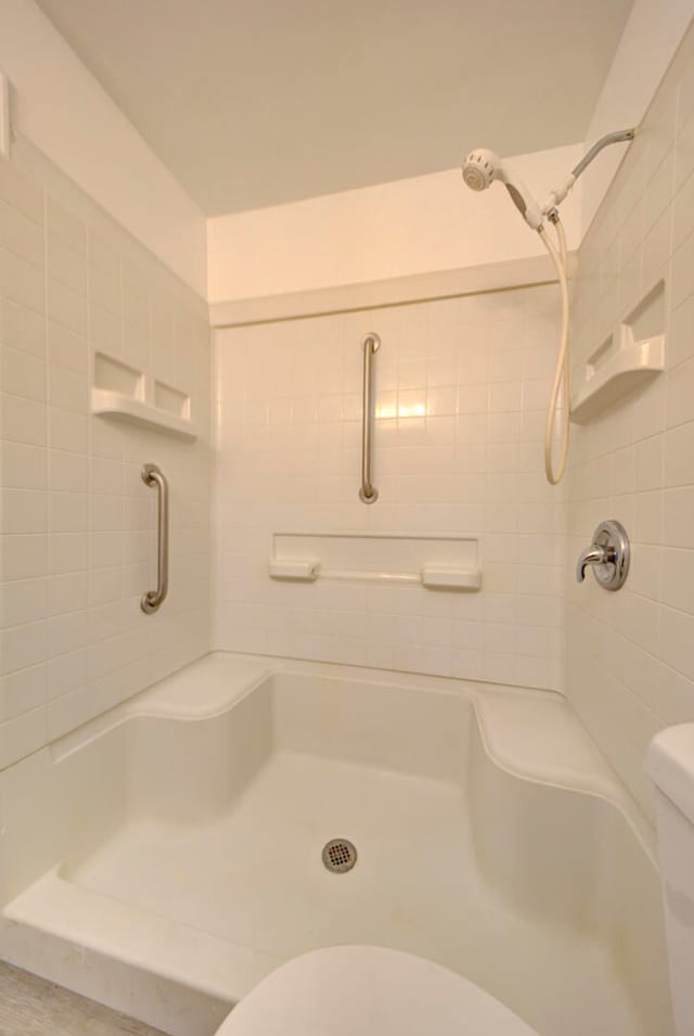 bathroom with tiled shower and toilet