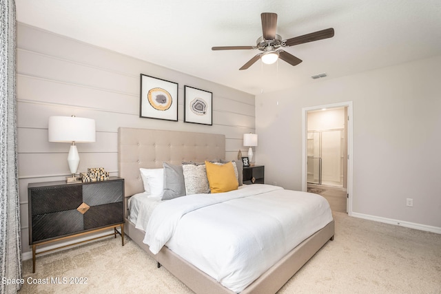 carpeted bedroom with ensuite bath and ceiling fan