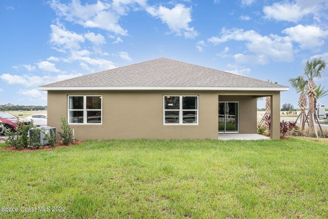 rear view of property featuring a lawn