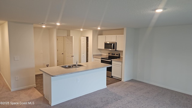 kitchen with light carpet, appliances with stainless steel finishes, sink, white cabinetry, and an island with sink