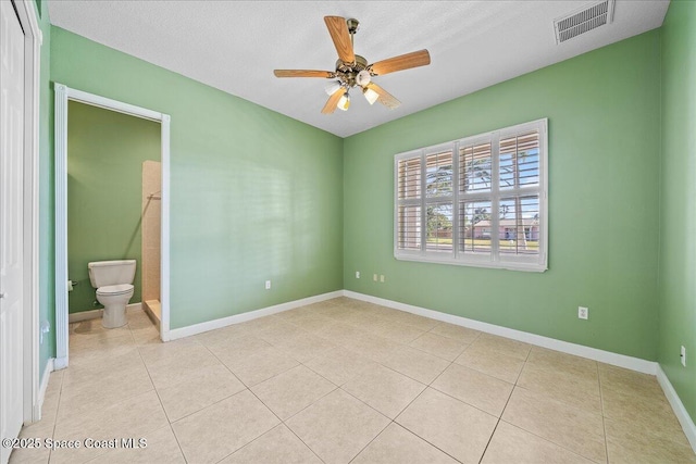 tiled empty room featuring ceiling fan