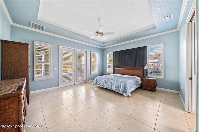 tiled bedroom featuring french doors, crown molding, a textured ceiling, access to outside, and a raised ceiling