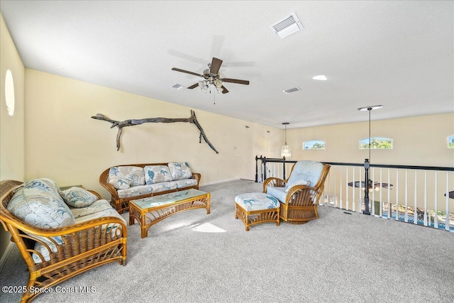 sitting room with a textured ceiling, carpet floors, and ceiling fan