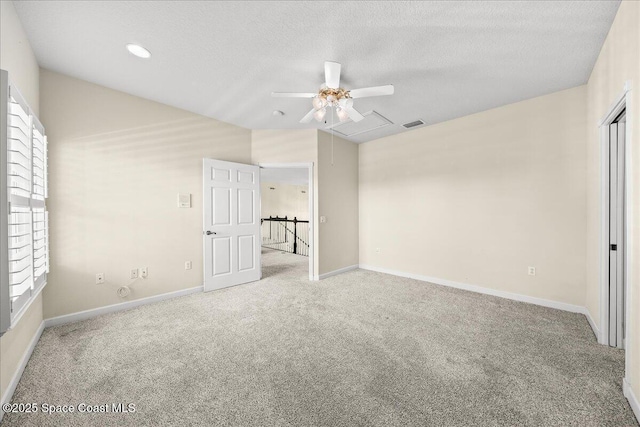 unfurnished bedroom with ceiling fan, vaulted ceiling, light carpet, and a textured ceiling