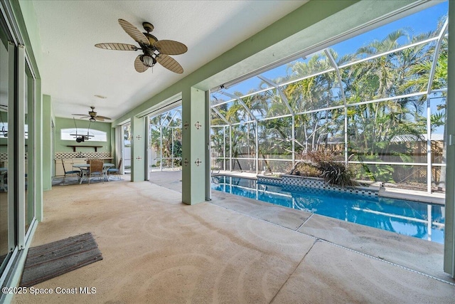 view of swimming pool featuring a patio, ceiling fan, and glass enclosure