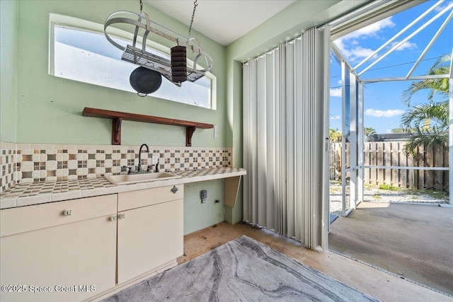 kitchen with white cabinetry, sink, decorative backsplash, and a healthy amount of sunlight