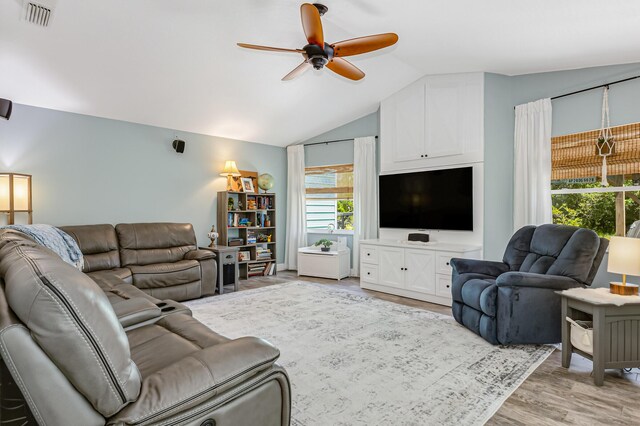 living room featuring ceiling fan, vaulted ceiling, and light wood-type flooring