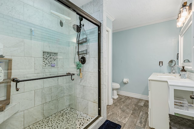 bathroom featuring crown molding, vanity, toilet, and a shower with shower door