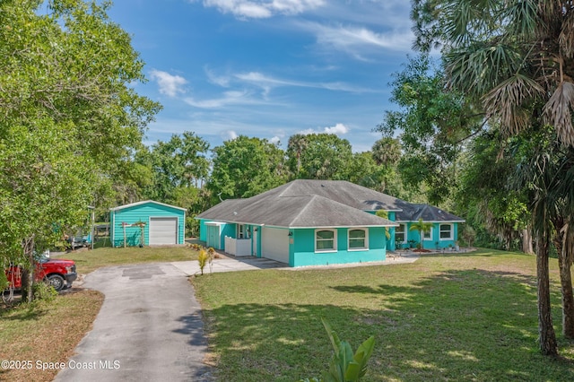 single story home featuring a garage, an outdoor structure, and a front yard