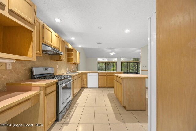 kitchen with light tile patterned flooring, decorative backsplash, stainless steel gas range, dishwasher, and kitchen peninsula