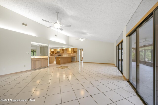 unfurnished living room with a textured ceiling, ceiling fan, and light tile patterned flooring