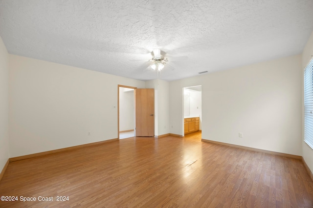 empty room with ceiling fan, hardwood / wood-style flooring, and a textured ceiling