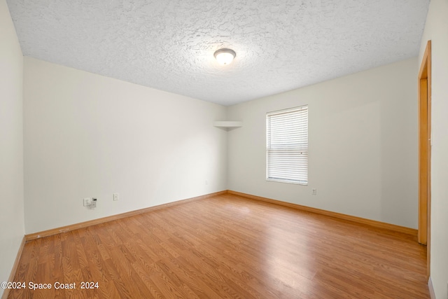 spare room featuring a textured ceiling and wood-type flooring