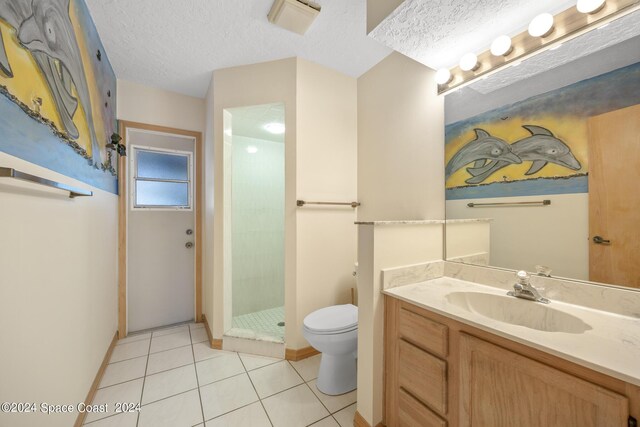 bathroom featuring a shower with door, toilet, vanity, tile patterned floors, and a textured ceiling