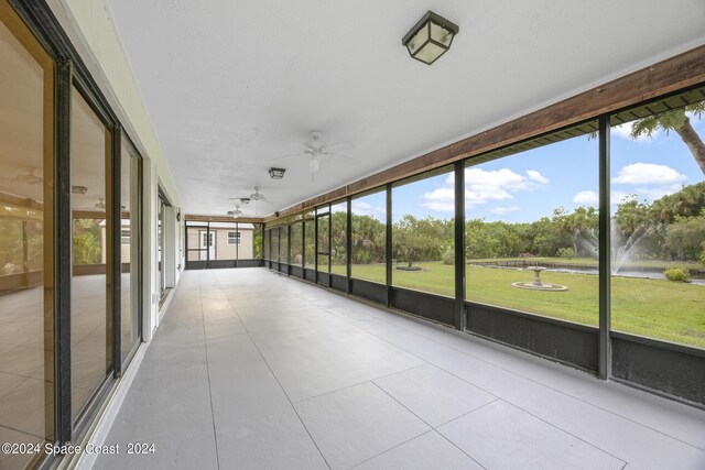 unfurnished sunroom featuring ceiling fan