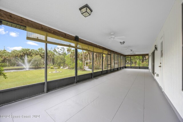 unfurnished sunroom with ceiling fan