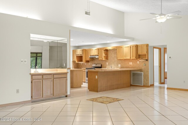 kitchen with ceiling fan, decorative backsplash, light tile patterned floors, and stove