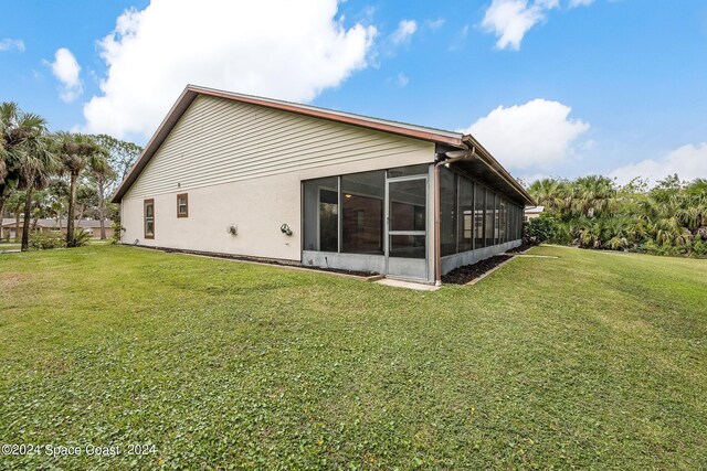 rear view of property with a sunroom and a lawn