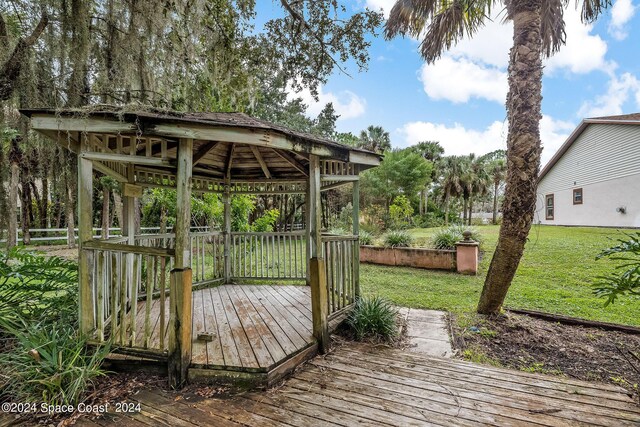 wooden deck featuring a gazebo and a lawn