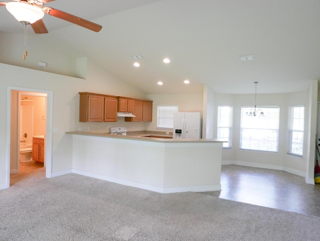 kitchen featuring white refrigerator with ice dispenser, stove, vaulted ceiling, light countertops, and hanging light fixtures