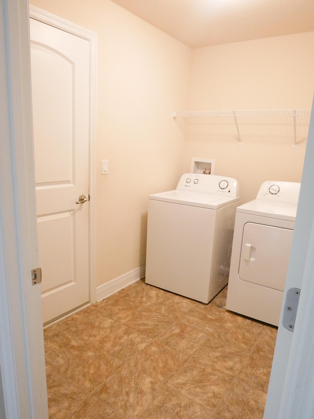 washroom with laundry area, baseboards, and independent washer and dryer