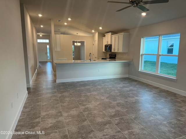 kitchen featuring lofted ceiling, kitchen peninsula, sink, white cabinetry, and appliances with stainless steel finishes