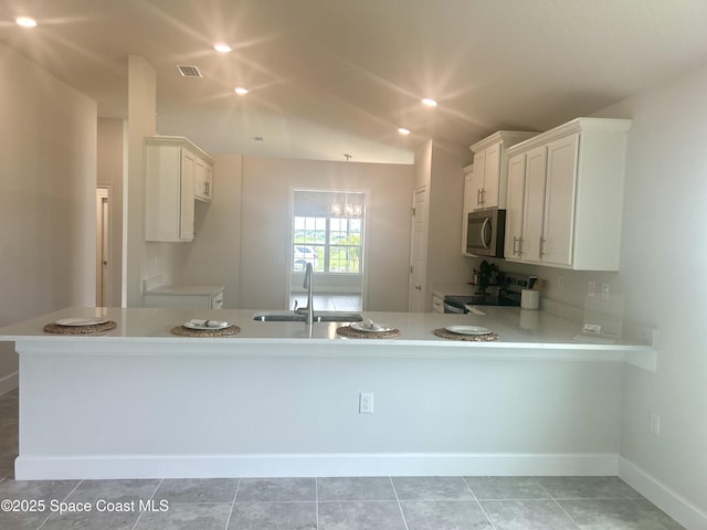 858 Soleway Dr, Palm Bay, FL 32907 - kitchen with a sink, stainless steel microwave, electric stove, light countertops, and white cabinets