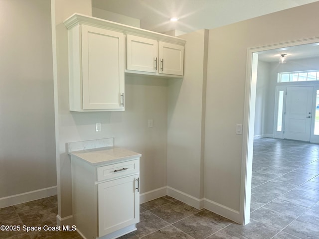 858 Soleway Dr, Palm Bay, FL 32907 - kitchen featuring baseboards, white cabinetry, and dark tile patterned floors
