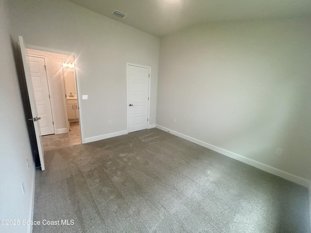 858 Soleway Dr, Palm Bay, FL 32907 - unfurnished bedroom with dark colored carpet, vaulted ceiling, and baseboards