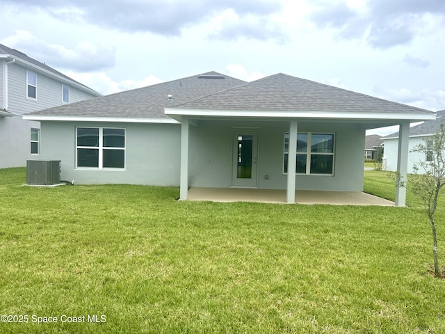 858 Soleway Dr, Palm Bay, FL 32907 - back of house with central AC, roof with shingles, a patio area, stucco siding, and a lawn