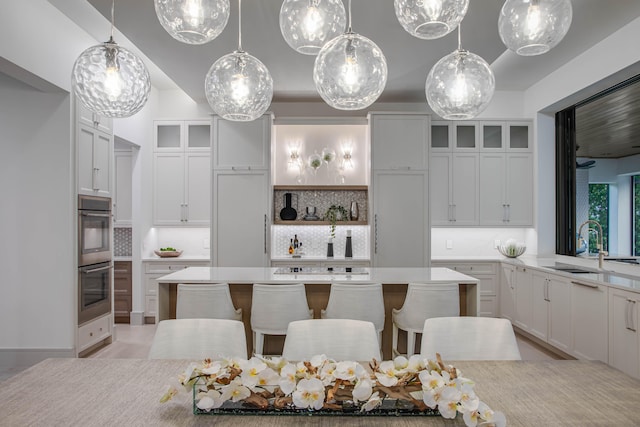 kitchen featuring a kitchen island, tasteful backsplash, hanging light fixtures, and a breakfast bar