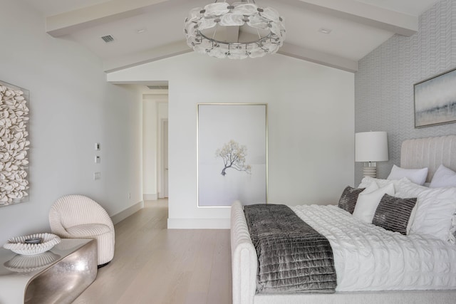 bedroom with lofted ceiling with beams and hardwood / wood-style floors