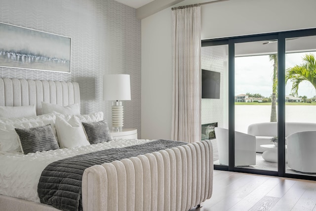 bedroom featuring wood-type flooring and access to exterior