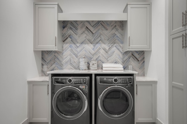 laundry area with cabinets and washer and clothes dryer