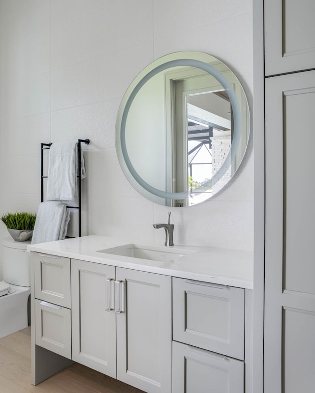 bathroom with wood-type flooring, toilet, and vanity