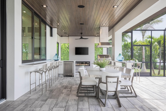 view of patio / terrace featuring grilling area, ceiling fan, and a bar