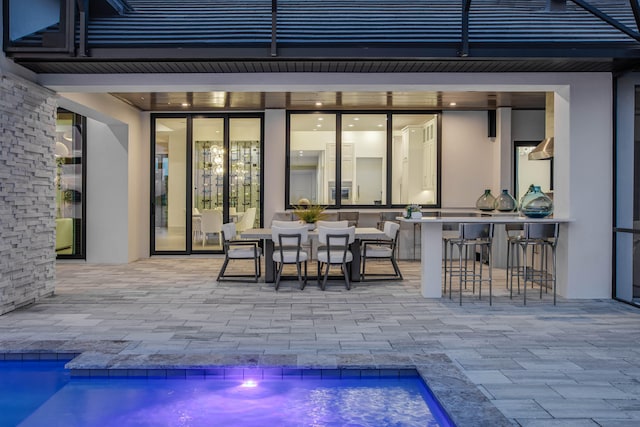 rear view of property with a bar and a patio area