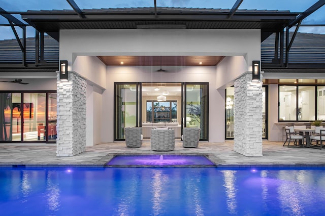 view of pool with glass enclosure, a patio area, and ceiling fan