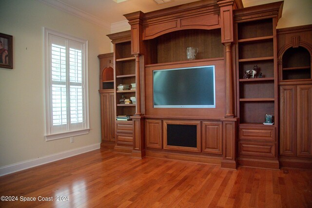 unfurnished living room featuring crown molding, plenty of natural light, and dark hardwood / wood-style floors